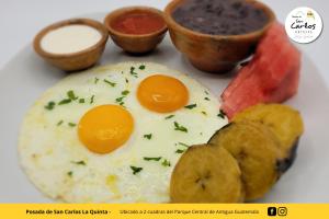 a plate with two eggs and other food on it at Posada de San Carlos La Quinta in Antigua Guatemala