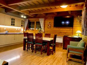 a kitchen with a table and chairs and a tv at Apartmán Vŕšky Terchová in Terchová