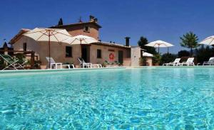 a large swimming pool with a house in the background at Country House Casco Dell'Acqua in Trevi