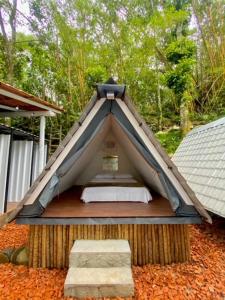 a bed in a teepee tent in a yard at Aquário Glamping in Abraão