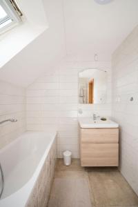 Baño blanco con bañera y lavamanos en Ayni apartman, en Semily
