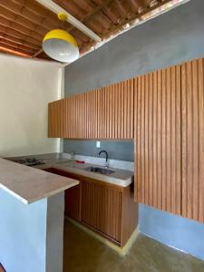 a kitchen with a sink and wooden cabinets at Aquário Glamping in Abraão