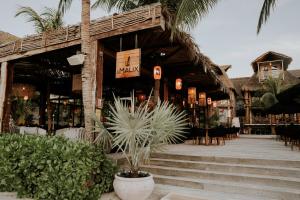 Aldea Kuká, Luxury Eco Boutique Hotel في جزيرة هول بوكس: مطعم فيه درج وكراسي والنخيل