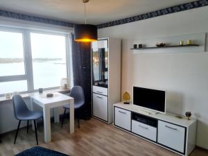 a living room with a white table and a television at Ferienwohnung NEXUS in Schleswig