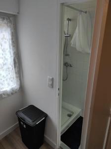 baño con ducha y cubo de basura negro en T2 Duplex Pamiers Plein Centre - Logement entier - Nouveau, en Pamiers