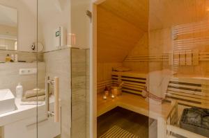 La salle de bains est pourvue d'un sauna avec une porte en verre. dans l'établissement Kleine Kirr, à Zingst