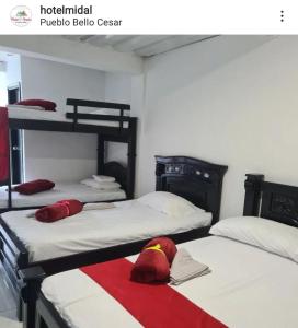 a room with two beds with red pillows on them at MIRADORES D ALESSANDRA in Pueblo Bello
