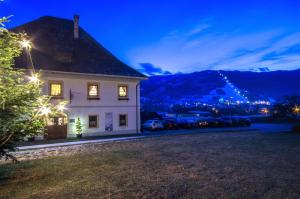 ein weißes Haus mit Autos, die nachts auf einem Hof geparkt sind in der Unterkunft Gasthof Kreischberg in Sankt Georgen ob Murau