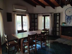 ein Esszimmer mit einem Holztisch und Stühlen in der Unterkunft Casa del arroyo in Villa General Belgrano