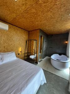 1 dormitorio con cama y bañera en Oka Vivah - Chale Oka da Montanha, en Jaboticatubas