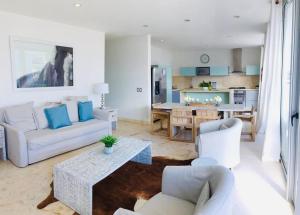 a living room with a couch and chairs and a table at Casa Moderna Fresca and The PoolClub at Mahogany Bay! in San Pedro