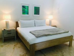 1 dormitorio con 1 cama grande y 2 lámparas en una mesa en Casa Moderna Fresca and The PoolClub at Mahogany Bay! en San Pedro