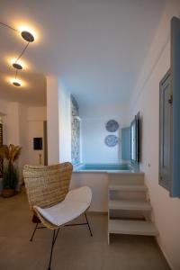 a living room with a chair and stairs at Infinity Blue Suites & Spa in Astypalaia Town