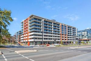 a large apartment building on the corner of a street at Cozy 1BR Apartment in the heart of Canberra in Canberra
