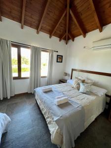 una camera da letto con un grande letto con lenzuola bianche di Wayra Huasi a Cafayate