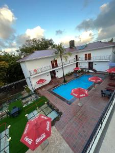 an overhead view of a hotel with a pool and red umbrellas at Hotel Totara in Dar es Salaam