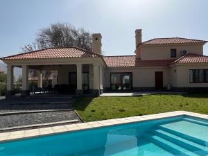 a house with a swimming pool in front of it at Estancia de Cafayate Wayra Huasi in Cafayate