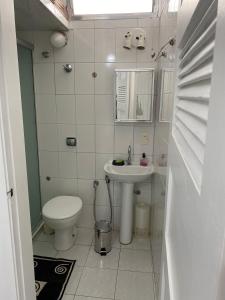 une petite salle de bain avec toilettes et lavabo dans l'établissement Guaruja Pitangueiras apto na praia, à Guarujá 16 autres photos