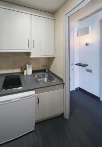 a kitchen with white cabinets and a sink at Stay U-nique Apartments Beltrán i Rózpide in Barcelona