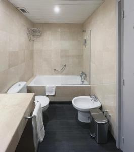 a bathroom with a tub and a toilet and a sink at Stay U-nique Apartments Beltrán i Rózpide in Barcelona