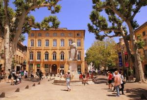 a group of people walking around a building with a statue at Appartement T2 Cosy sur Aix in Aix-en-Provence