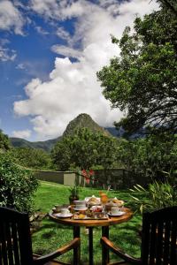 
a table topped with plates of food on top of a lush green hillside at Sanctuary Lodge, A Belmond Hotel, Machu Picchu in Machu Picchu
