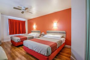 2 Betten in einem Hotelzimmer mit roten Wänden in der Unterkunft Motel 6-Nephi, UT in Nephi