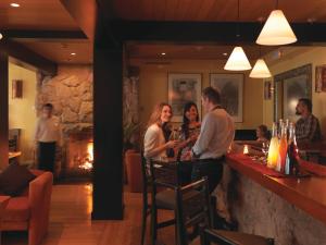 um grupo de pessoas em pé em um bar em um restaurante em Sanctuary Lodge, A Belmond Hotel, Machu Picchu em Machu Picchu