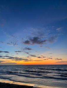 einen Sonnenuntergang am Strand mit dem Meer in der Unterkunft Cabañas Estrella de Mar, Palmar del viento, Moñitos in Moñitos
