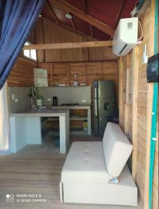 eine Küche mit einem Kühlschrank und einem Tisch im Zimmer in der Unterkunft Cabañas Estrella de Mar, Palmar del viento, Moñitos in Moñitos