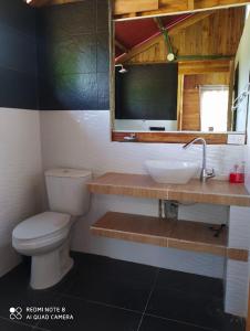 ein Badezimmer mit einem WC, einem Waschbecken und einem Spiegel in der Unterkunft Cabañas Estrella de Mar, Palmar del viento, Moñitos in Moñitos