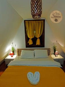 Vila Sreća - Kolašin في كولاسين: غرفة نوم بسرير اصفر مع ستائر صفراء