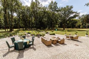 a patio with tables and chairs in a park at PALAC DABROWKA in Rawicz