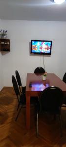 mesa con sillas y TV en la pared en Apartmán priamo v centre mesta Levice, en Levice