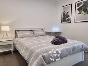 um quarto com uma cama grande e duas mesas de cabeceira em Modern new 1-bedroom apartment in Canberra City em Camberra