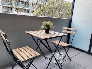 a wooden table and two chairs on a balcony at Modern new 1-bedroom apartment in Canberra City in Canberra +9 photos