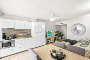 eine Küche und ein Wohnzimmer mit einem Tisch und einem Sofa in der Unterkunft Hotel Drift 4202 in Palm Cove