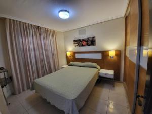 ein kleines Schlafzimmer mit einem Bett und einem Fenster in der Unterkunft Apartamentos Albatros Golf del Sur Tenerife in San Miguel de Abona