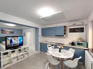 a kitchen with blue cabinets and a table and chairs at Studio'24 - Adults Only in Constanţa
