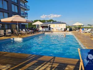 une piscine dans un hôtel avec des gens dans l'eau dans l'établissement Apartamenty IGMA, à Sarbinowo