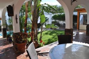 un patio con mesa, sillas y un árbol en Bonita casa cálida para el relax con wifi, en Valsequillo