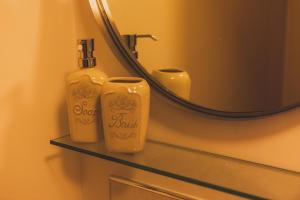 uma casa de banho com duas garrafas de sabão numa prateleira ao lado de um espelho em Station Suite – Simple2let Serviced Apartments em Halifax