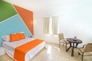 Hotel Punta Palmeras في غير متوفر: غرفة نوم بسرير وطاولة وكراسي
