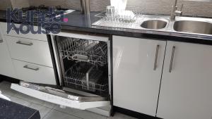 an empty dishwasher in a kitchen next to a sink at Kunda House Bournbrook in Birmingham