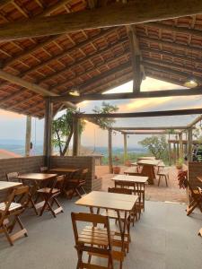 un groupe de tables et de chaises dans un restaurant dans l'établissement Casa Erva Doce Pousada, à Delfinópolis