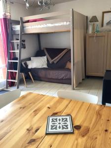 拉姆吉的住宿－Beau Studio La Mongie Tourmalet Pic du Midi，客房设有两张双层床,铺有木地板。