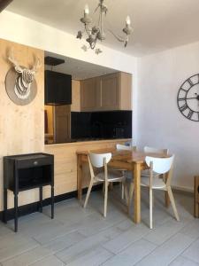 拉姆吉的住宿－Beau Studio La Mongie Tourmalet Pic du Midi，厨房配有木桌、椅子和时钟