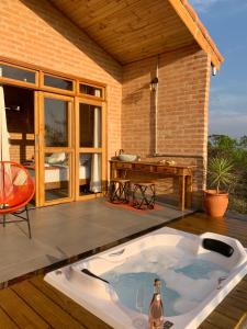una vasca da bagno seduta su un patio con tavolo di Casa Erva Doce Pousada a Delfinópolis