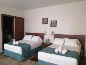 2 łóżka w pokoju hotelowym z ręcznikami w obiekcie Casa Esmeralda Hotel w mieście Oaxaca
