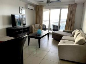 a living room with a couch and a tv at Sand Bar Condo - 1BR Suite next to The Morgan Resort in Maho Reef